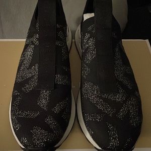 Michael Kors slip on tennis shoe, black with silver MK logo print, size 7 1/2
